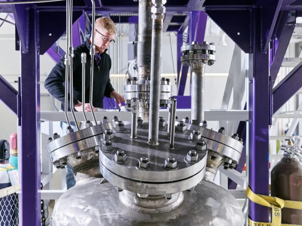Man working in engineering laboratory room with industrial equipment.